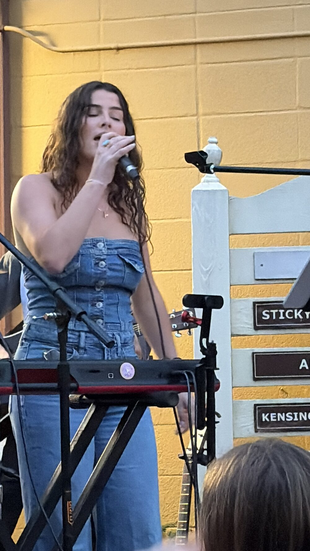Kailey Jane singing with her eyes closed at GIGS Courtyard in Kensington, Maryland