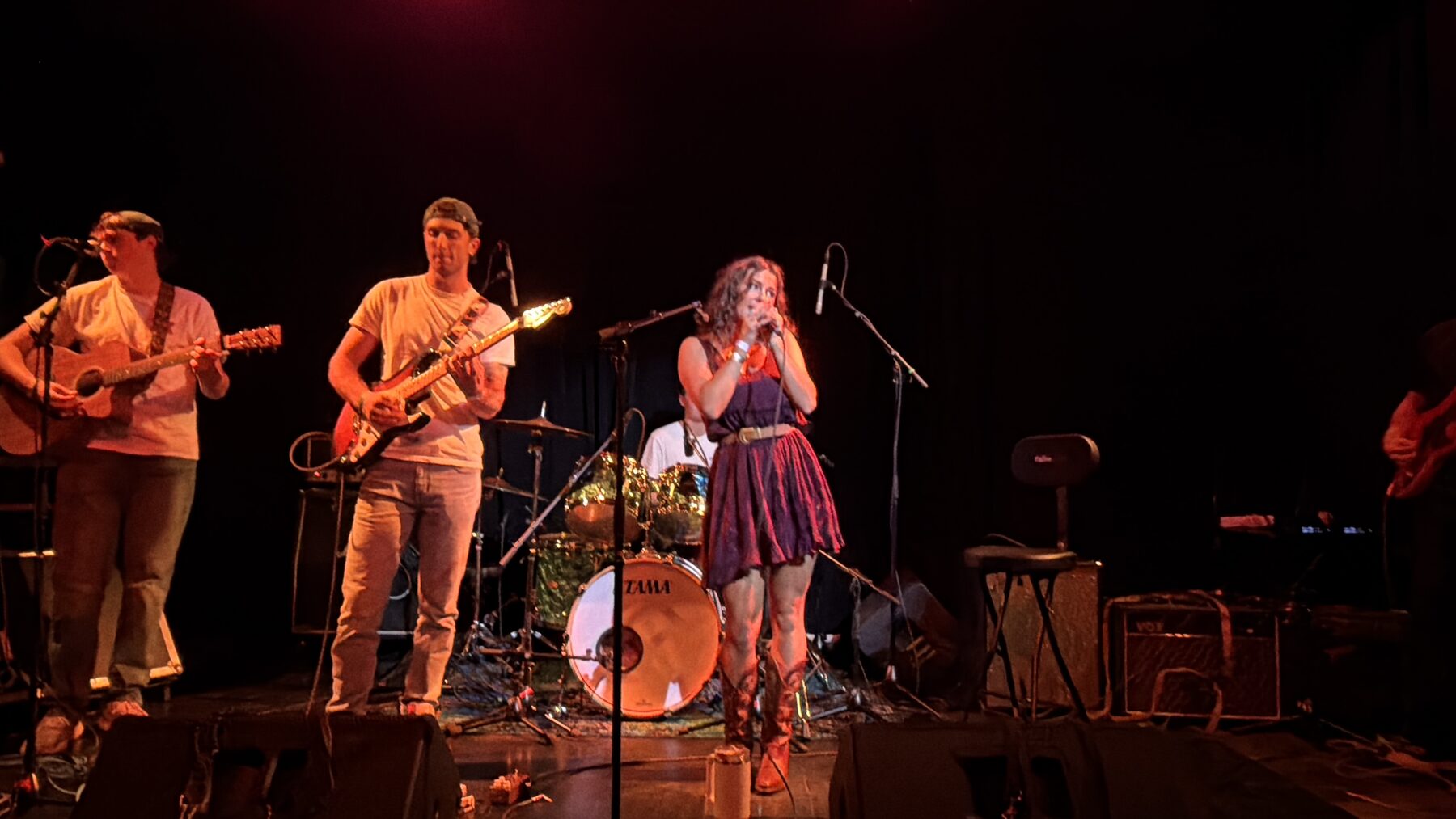 Kailey Jane and her full band mid-song under warm light at Pearl Street Warehouse