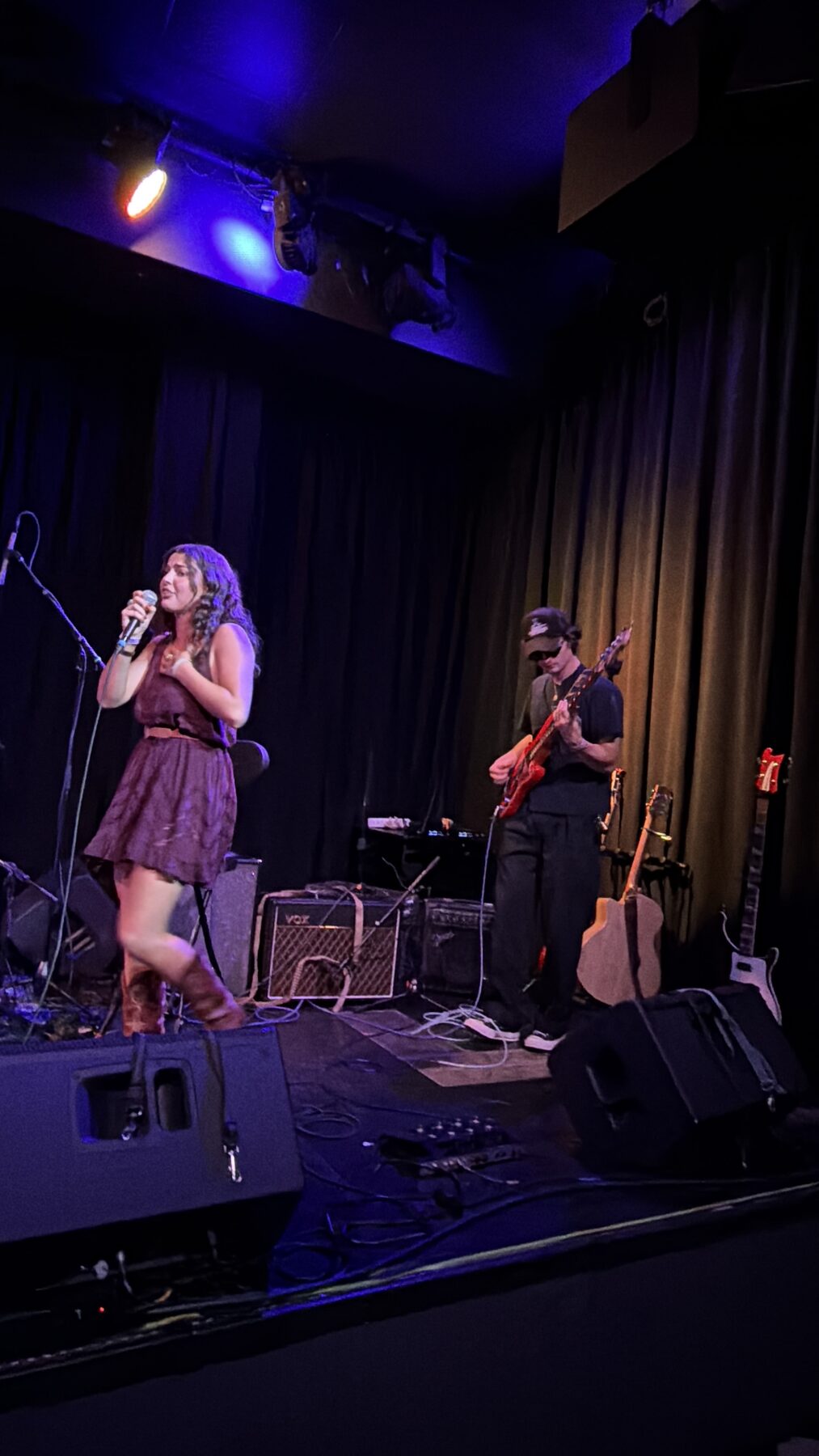 Kailey Jane singing with her hand on her heart at Pearl Street Warehouse